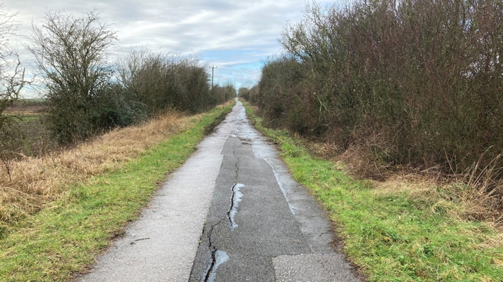 before photo of phoenix trail showing cracked and uneven surface with surface water 