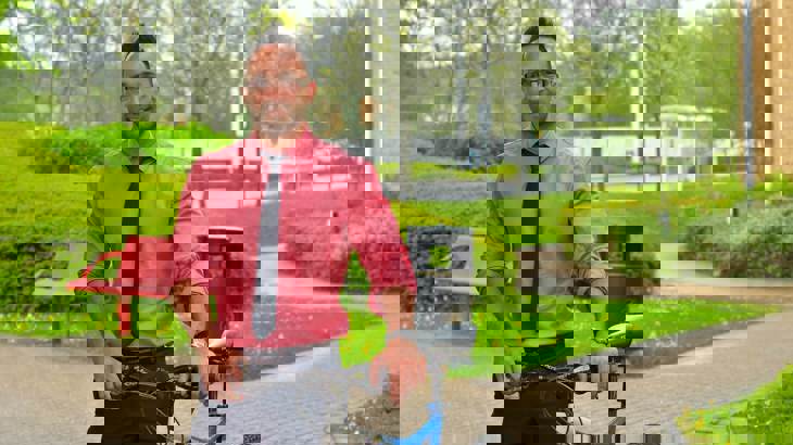 man in shirt and tie with his bike outside office building