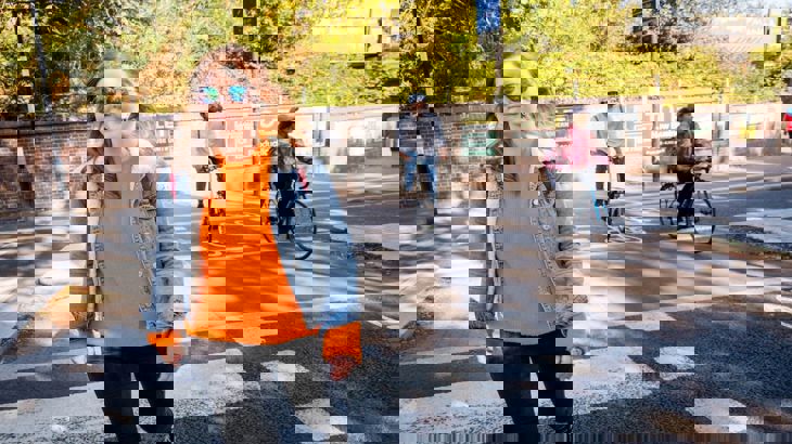 Woman walking on city street with people cycling in background