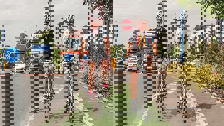 woman on bikes cycling in protected lane in a city