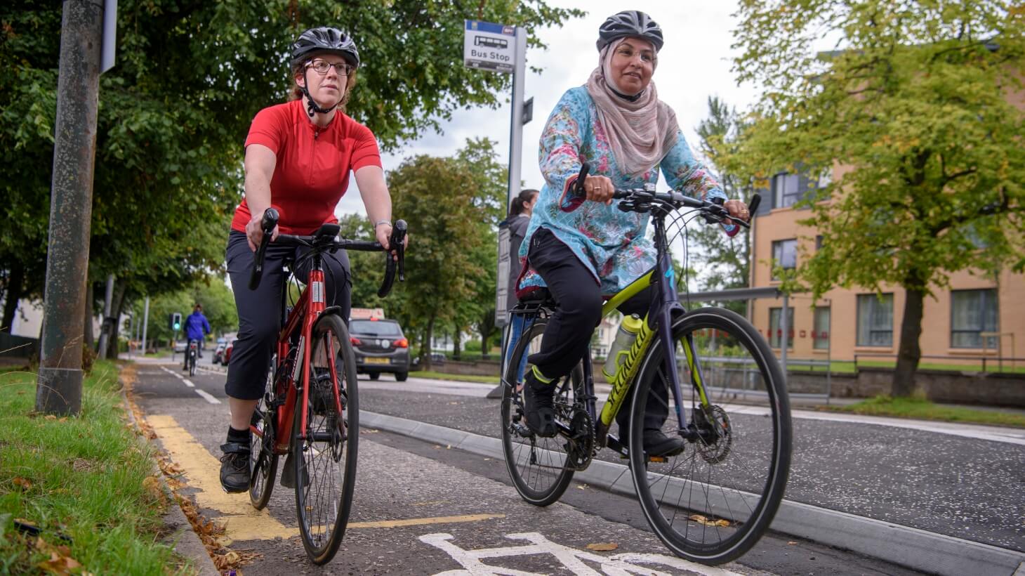 Two women cycling together on a segregated cycle lane
