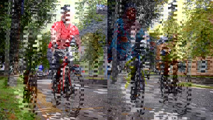 Two women cycling together on a segregated cycle lane