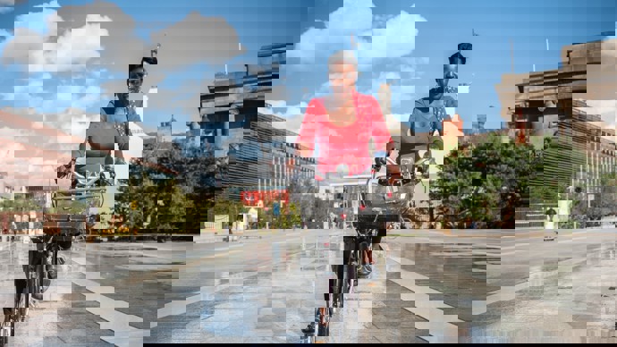 A women cycles through birmingham on a warm sunny day 