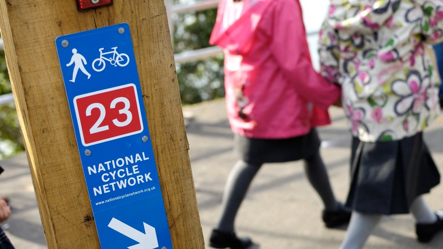 National Cycle Network route sign with two school children walking in background