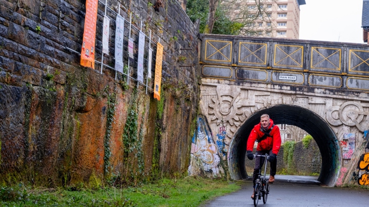 Jon Jewitt is pictured cycling beneath artist Hector Dyer’s installation It Is A Long Lane That Has No Turning' on National Cycle Network Route 7