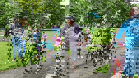 Dad with daughter in bike seat and other child on own bike next to him