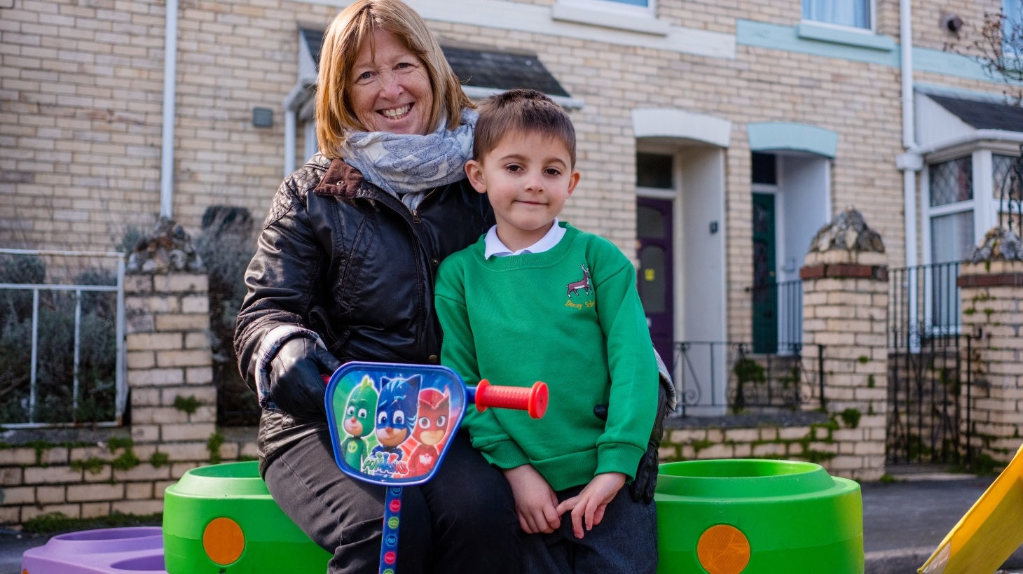 Child and family member sitting on Walk Wheel Cycle Trust street design kit at street closure event