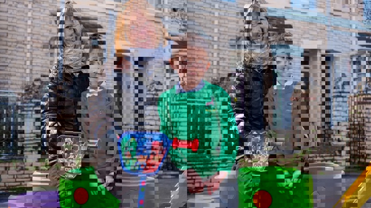 Child and family member sitting on Walk Wheel Cycle Trust street design kit at street closure event