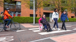 People walking and wheeling on the South City Way in Glasgow.