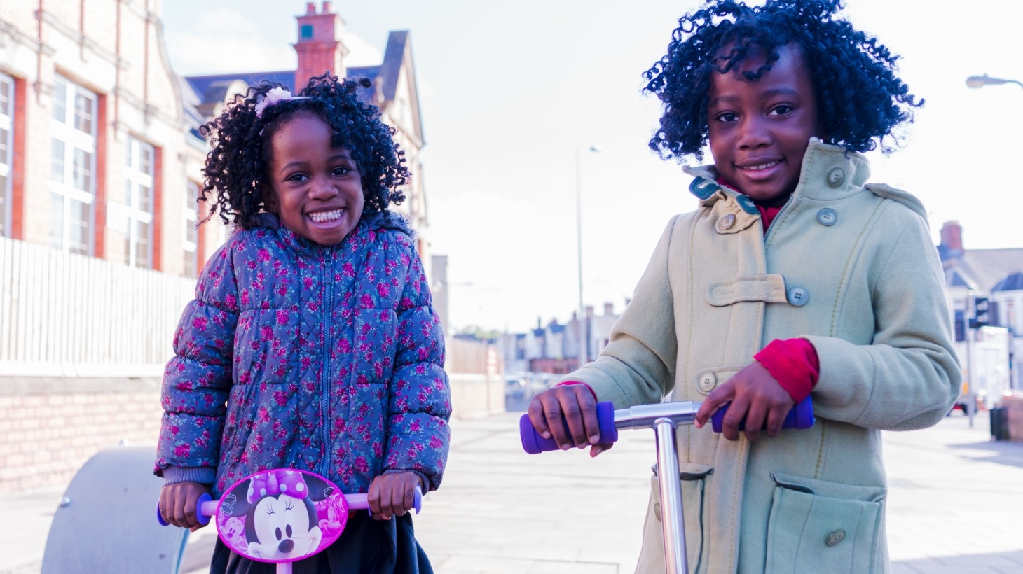 Two girls scooting to school