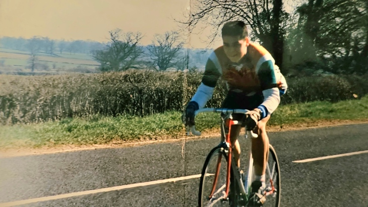 An old photograph of a young Paul Luttrell riding on his first road bike along a road in Somerset