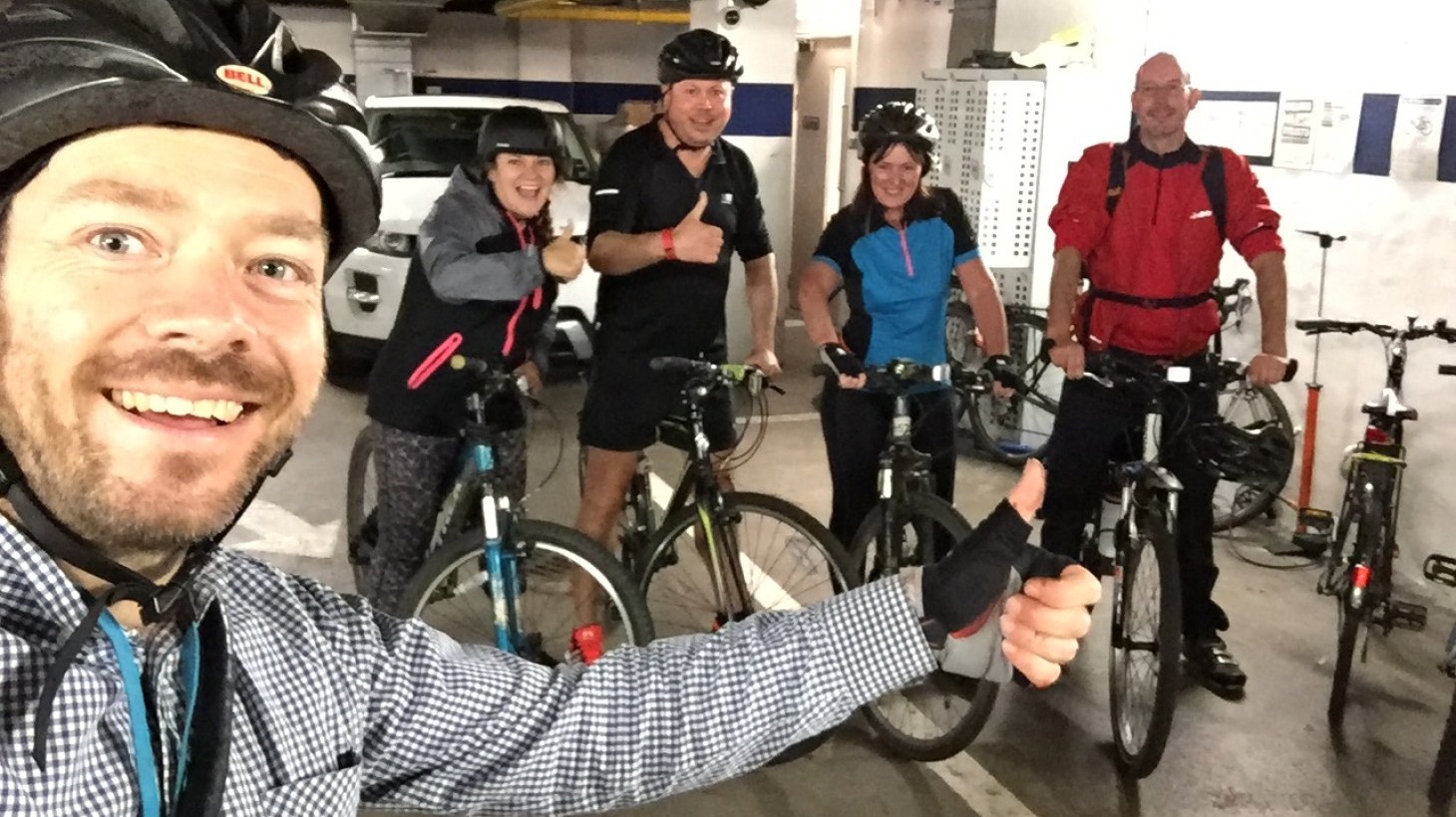Selfie of Walk Wheel Cycle Trust volunteer, Gordon, with a group of colleagues wearing helmets and posing with their bicycles