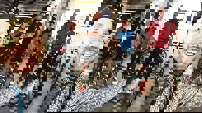 Selfie of Walk Wheel Cycle Trust volunteer, Gordon, with a group of colleagues wearing helmets and posing with their bicycles