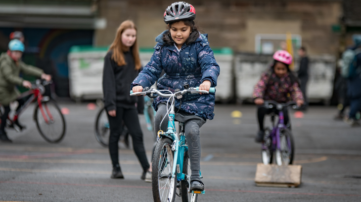 A group of schoolchildren cycling on bike ramps in the school playground
