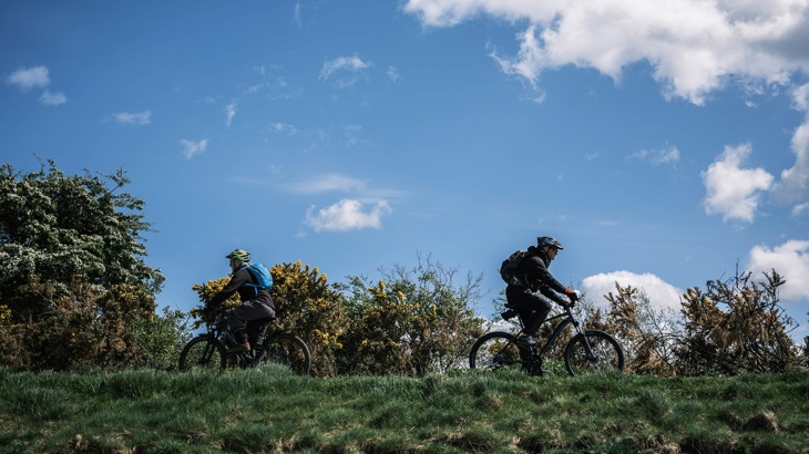 Cyclists ride past each other on a rural path in Inverness