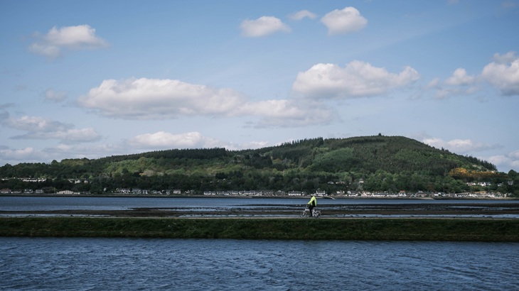A cyclist rides on a path in Inverness
