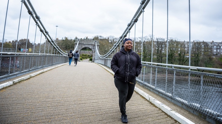 A person is pictured walking across a bridge over the River Dee in Aberdeen