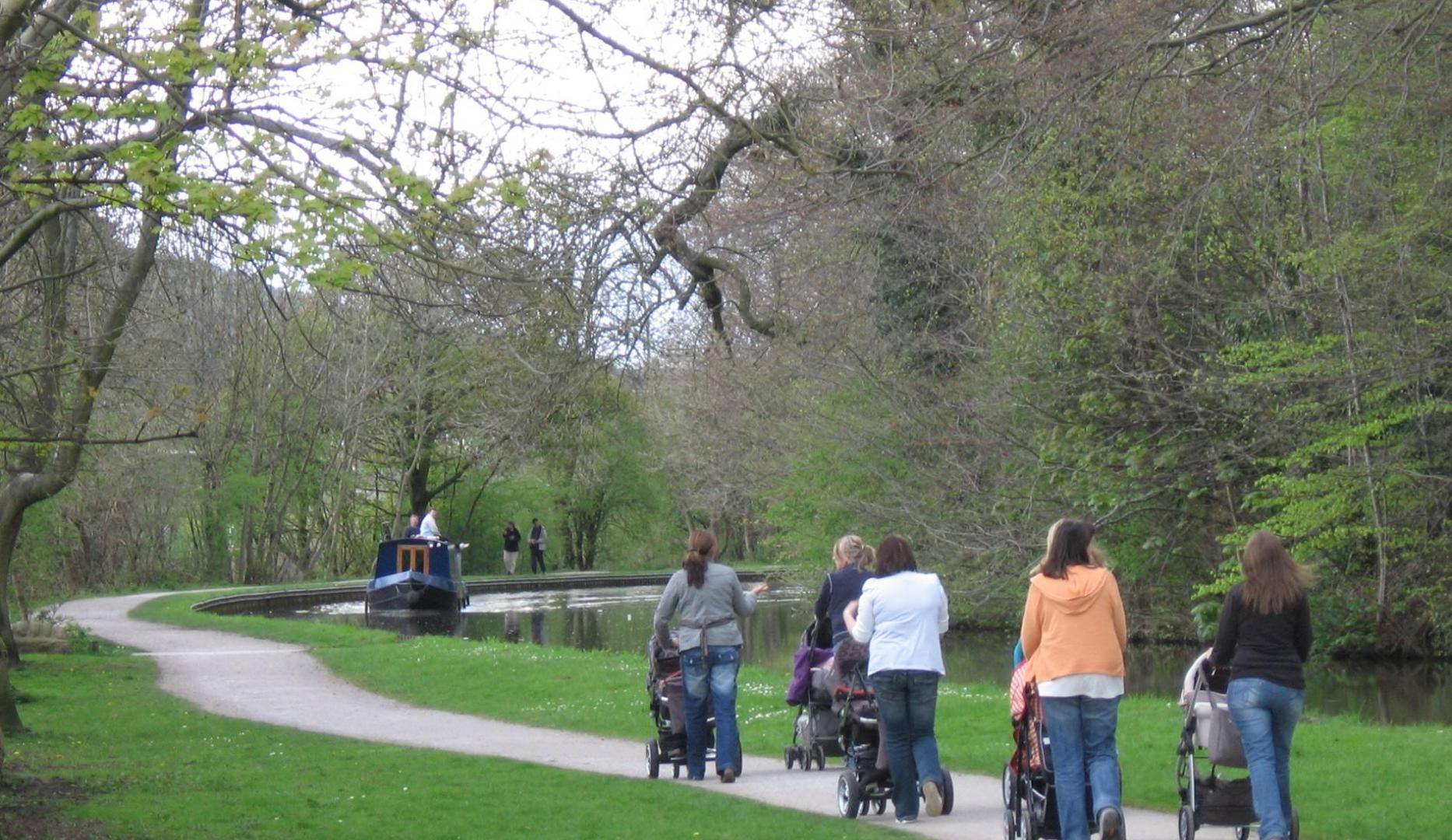 Mums with push chairs walking along canal route