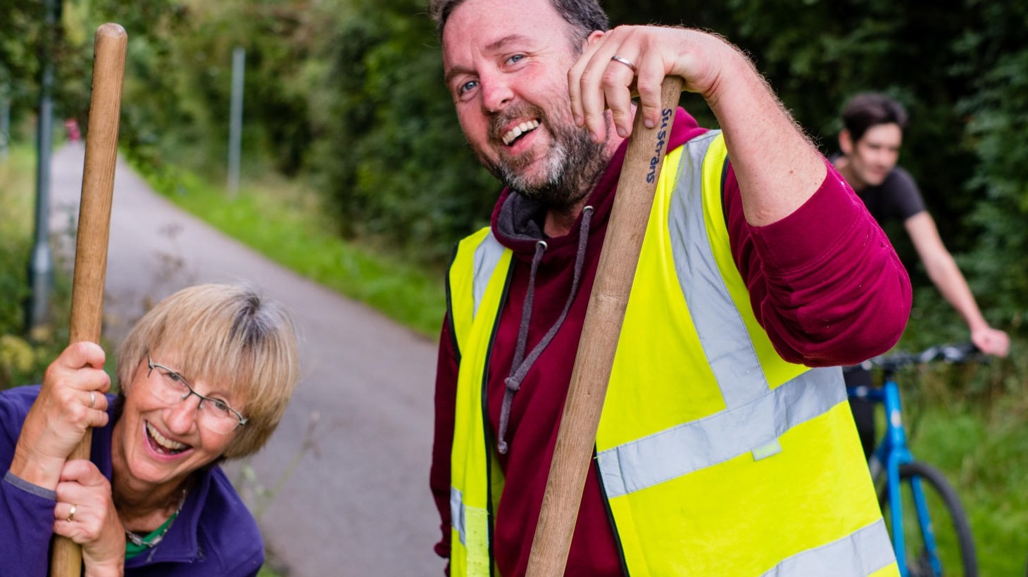 Two volunteers smiling on the NCN with brushes