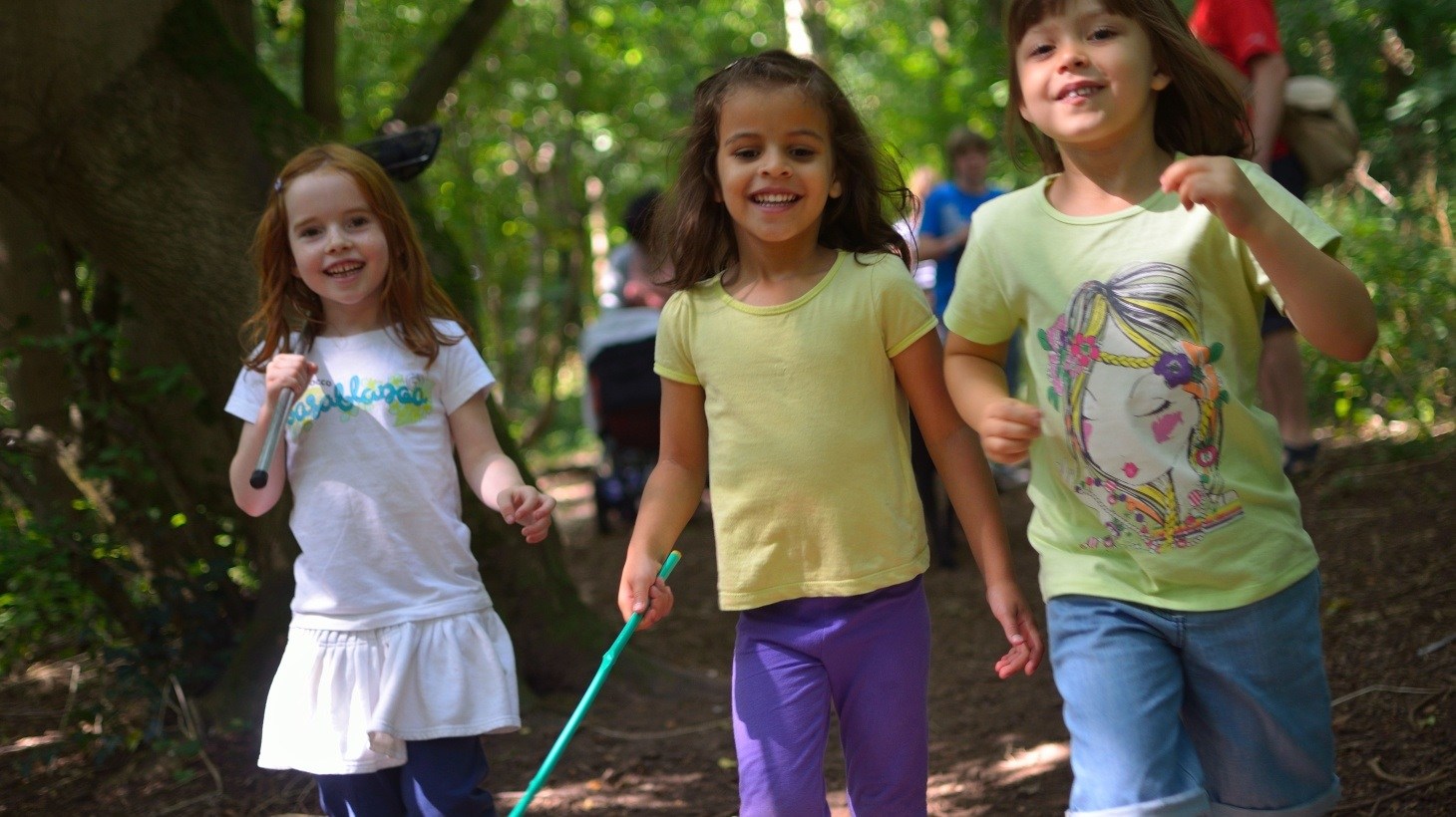 Three children playing in forest