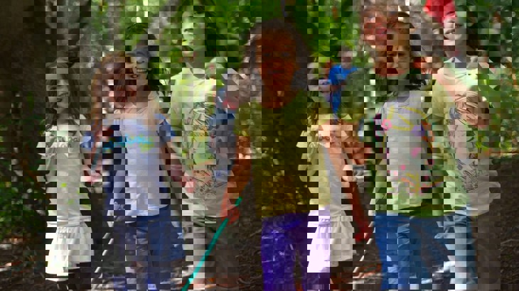 Three children playing in forest