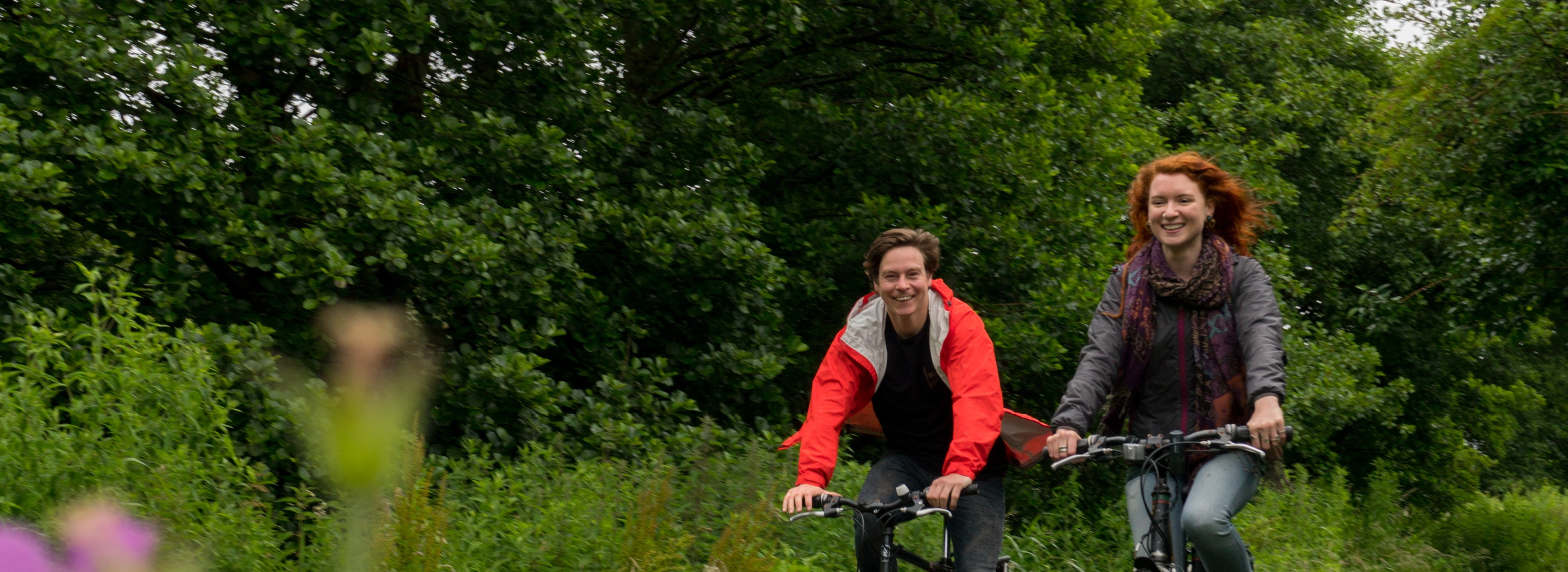 Two people cycling on a traffic-free path in Wales