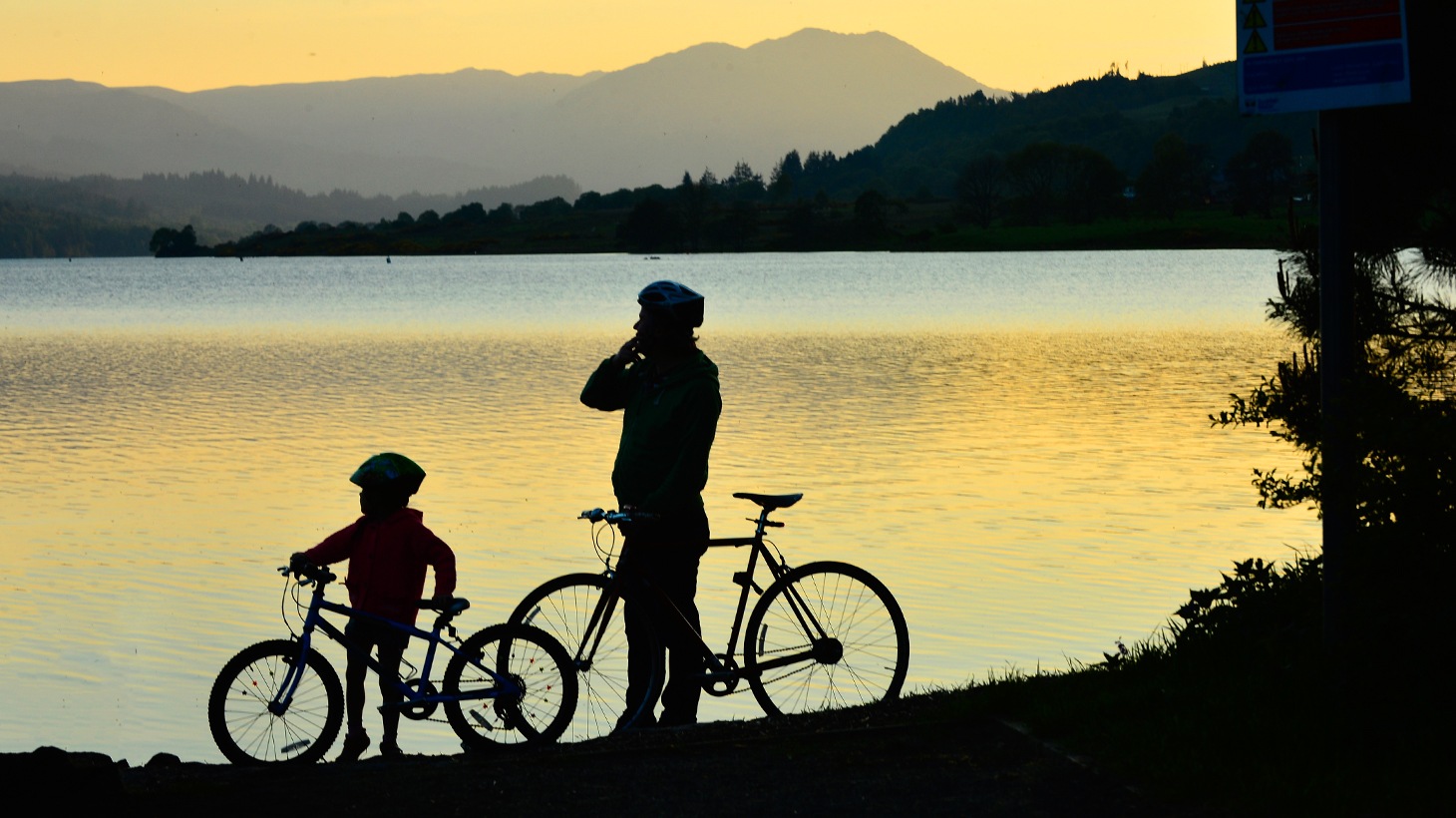 Silhouette of child and adult with bikes