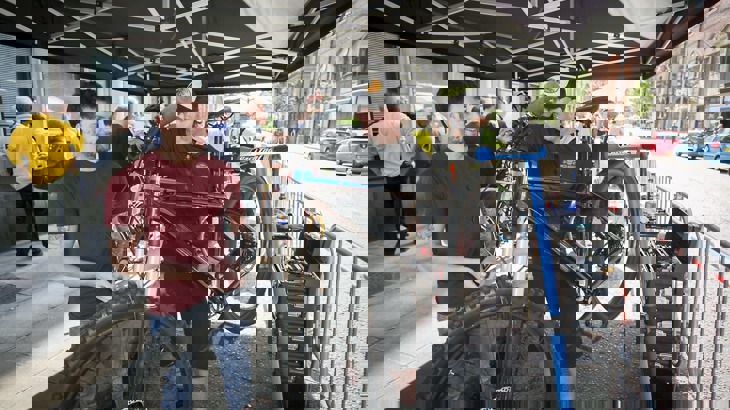 A man helps someone fix their bike at a bike maintenance workshop in belfast