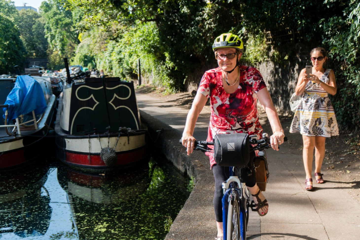 Woman cycling on canal towpath
