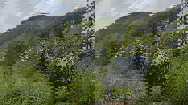 A Metal Sculpture Of A Cow On A Cycle Path 