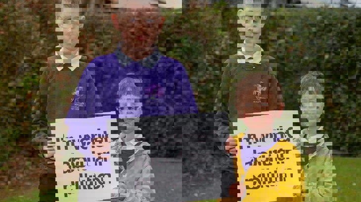 Two school boys holding sign about air pollution