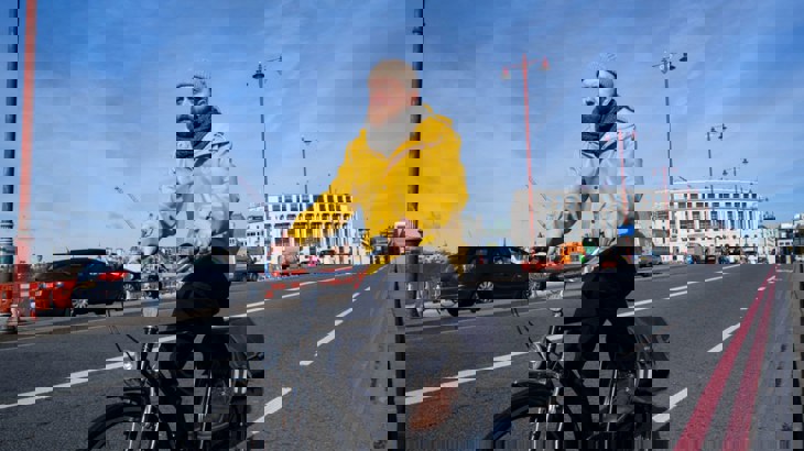 Man Cycling Over Bridge In London