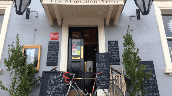 Front doorway of pub with blackboards and road bike leaning against the door