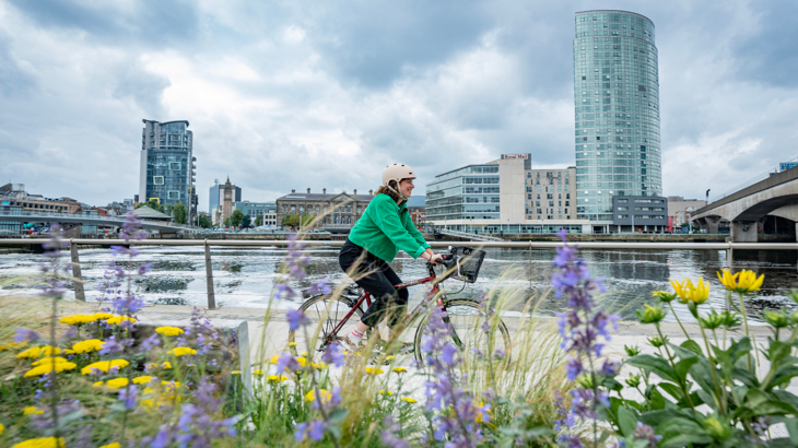 A person cycling to work along the Martime Mile.