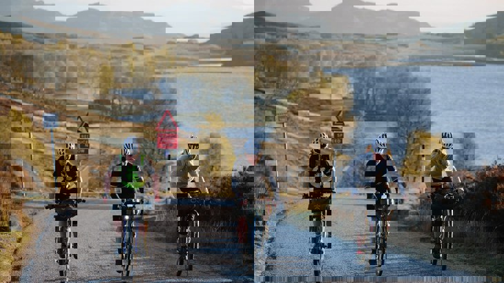 Three cycle tourers cycling along the Caledonia Way in Scotland