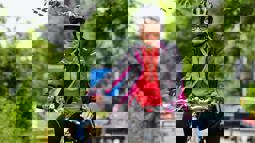 Lady stood with her bicycle wearing a helmet