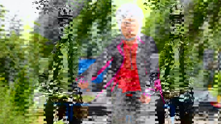 Lady stood with her bicycle wearing a helmet