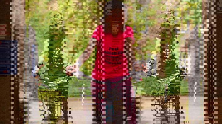 Lady smiling as she rides her trike through an archway