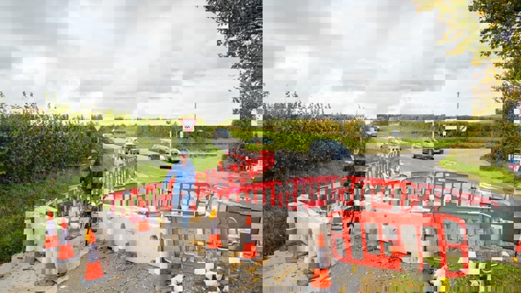 Man cycling through temporary barriers that prevent cars from using the road