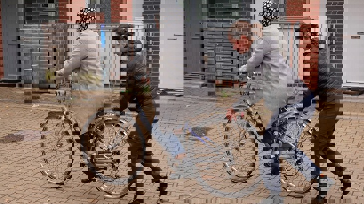 Cycle instructor helps woman to ride a bike