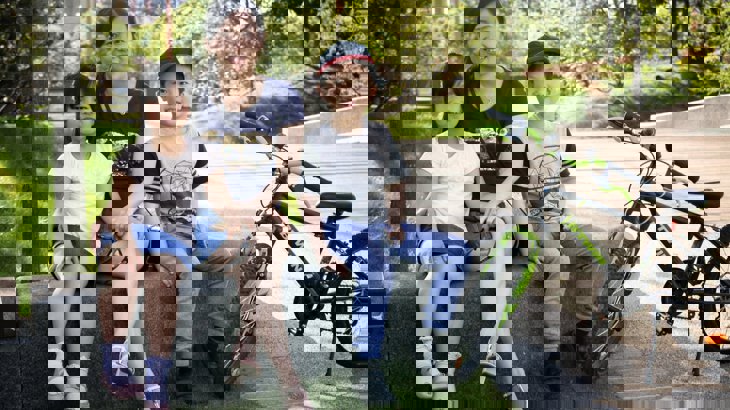 family sitting outside with a bike