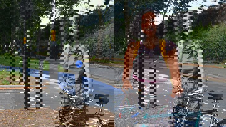 Our West Midlands partnerships manager, Ridhi Kalaria standing with her bike next to a segregated cycle path in the centre of Birmingham.