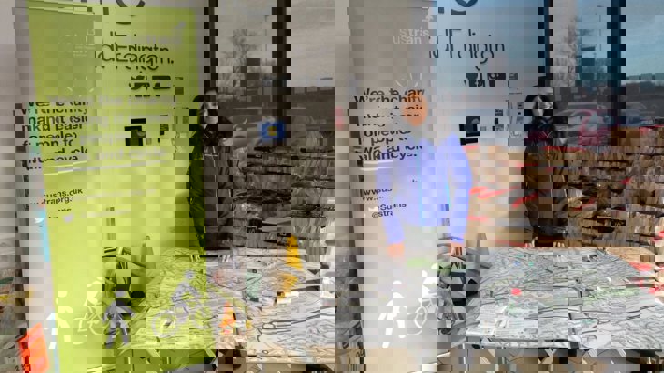 woman behind table with map on it next to Walk Wheel Cycle Trust banner