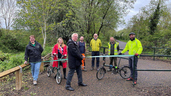 A small group of people gathered on a new section of the Trans Pennine Trail, ready to cut the ribbon to officially open the route.