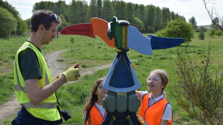 School volunteers painting milepost