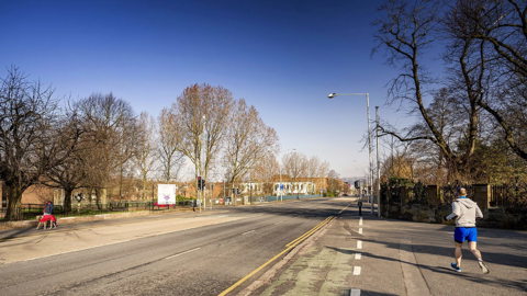 Lone jogger and dog walker on either side of empty road in Belfast, March 2020 Covid lockdown