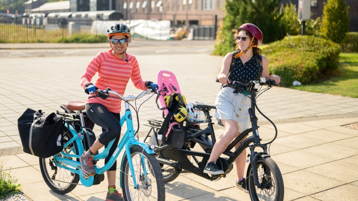 Two women standing with their e-bikes in Barry