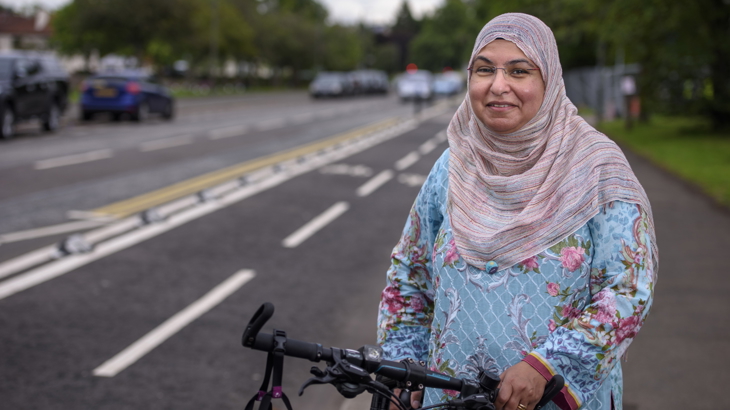 A woman in a pink hijab with a bike