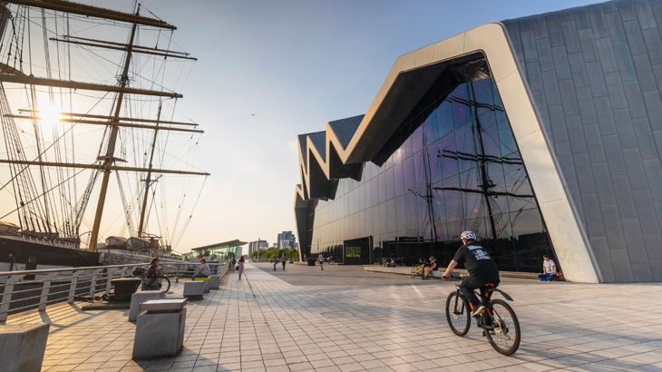 Person cycles past the Riverside Museum in Glasgow.