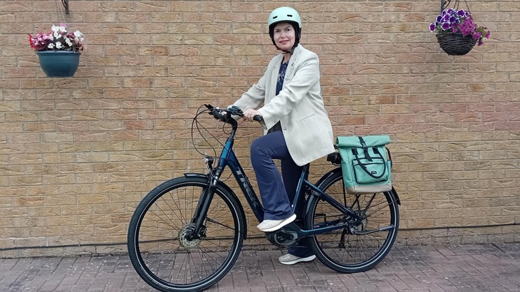 Woman wearing helmet on ebike in Derry